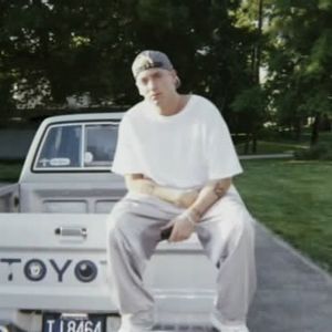 Eminem sitting on a toyota